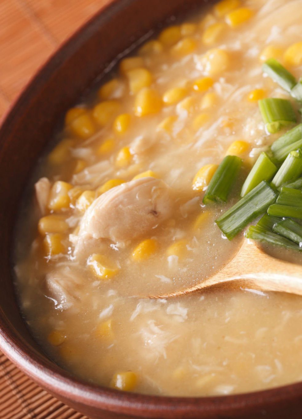 Chinese food: corn soup with chicken and onions in a bowl close-up. horizontal